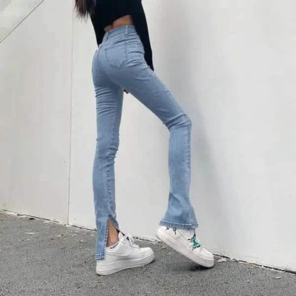 Light blue split-hem jeans paired with white sneakers.