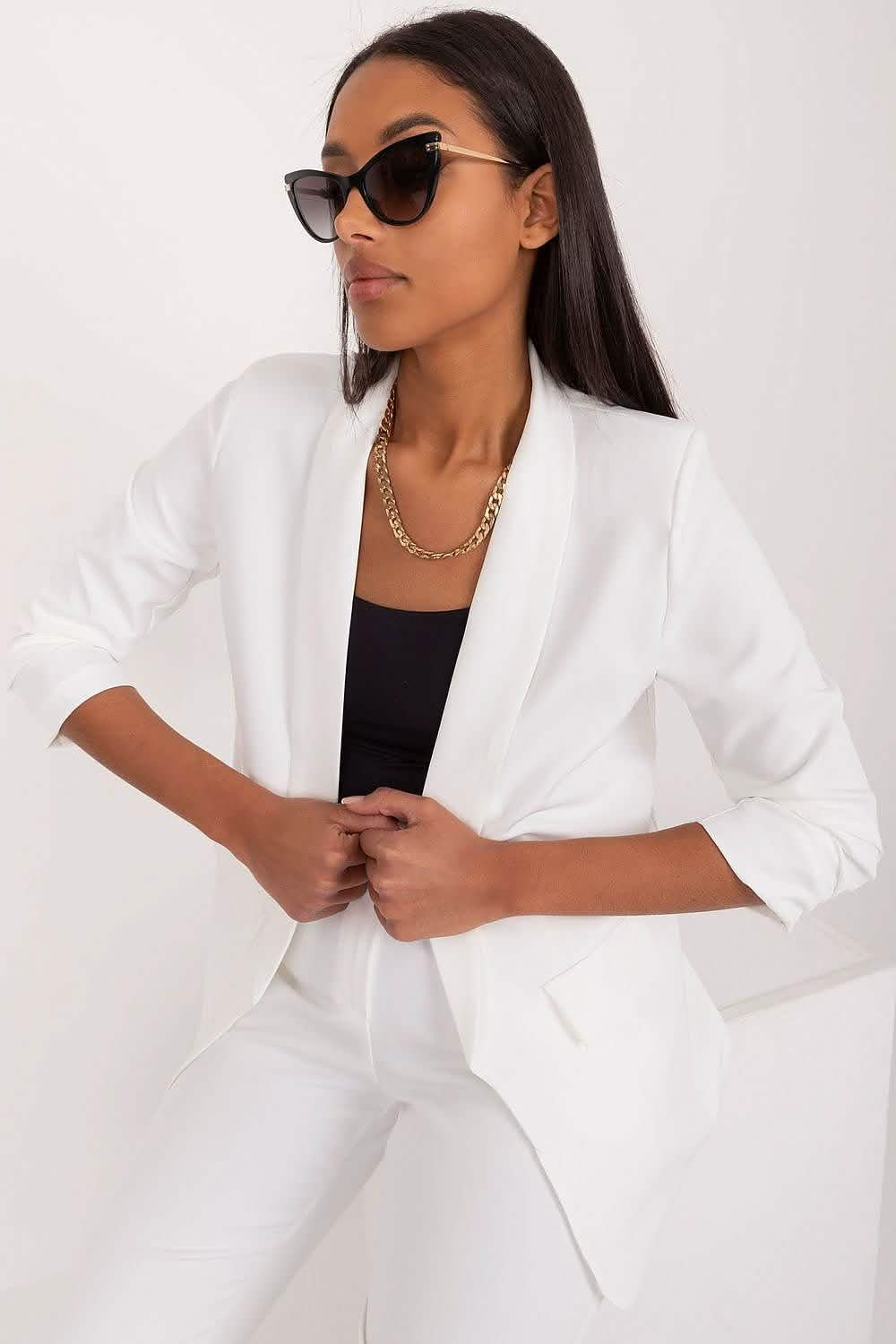 Crisp white blazer with rolled-up sleeves paired with matching white pants.