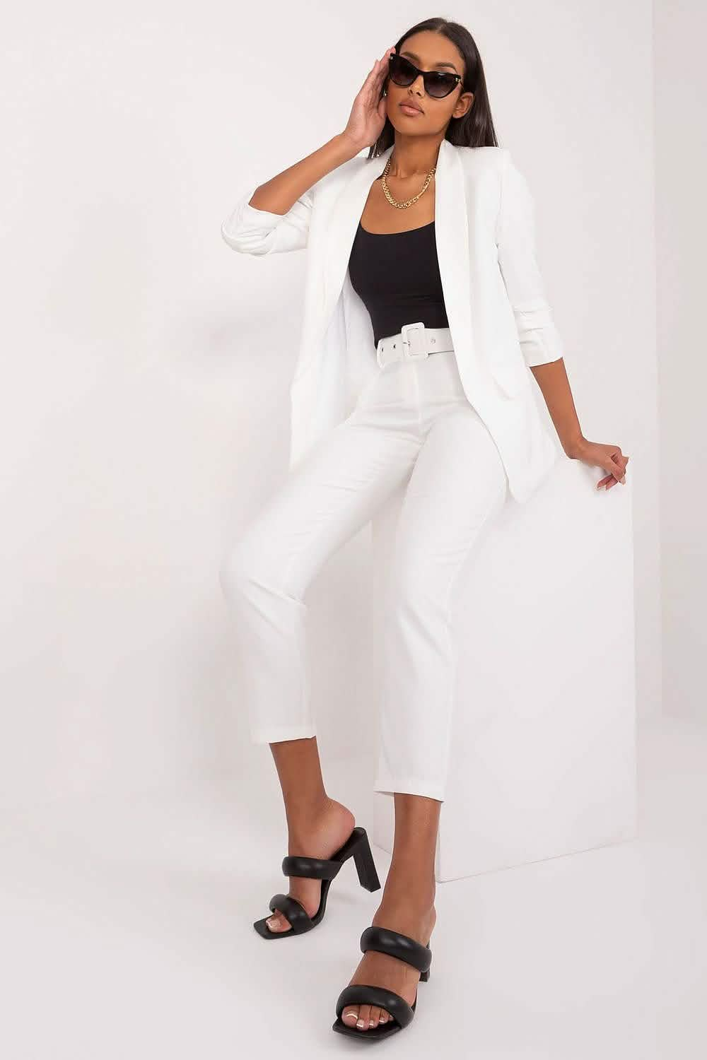 Crisp white pantsuit with cropped trousers paired with a black tank top and sandals.