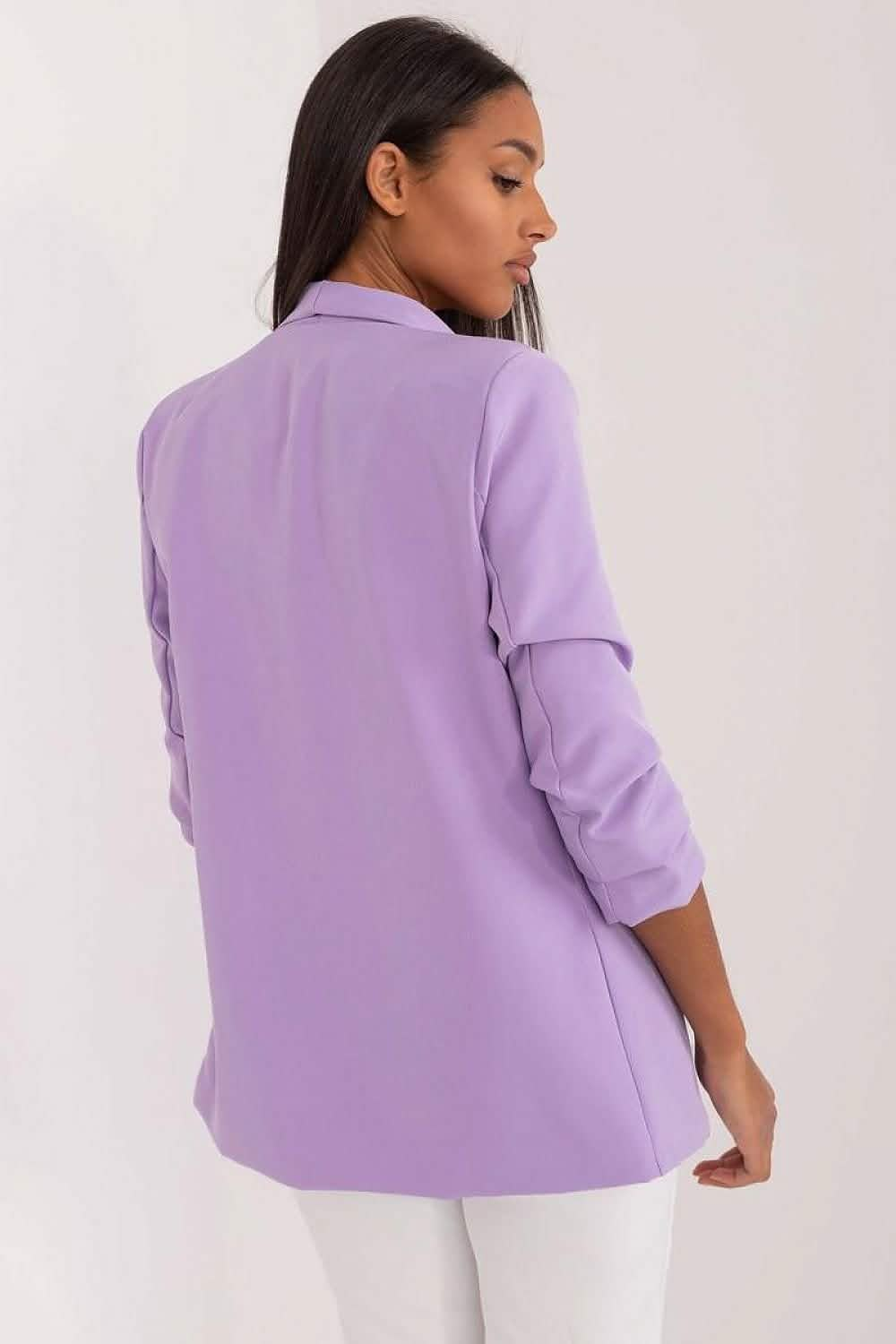 Lilac blazer with rolled-up sleeves worn with white pants.