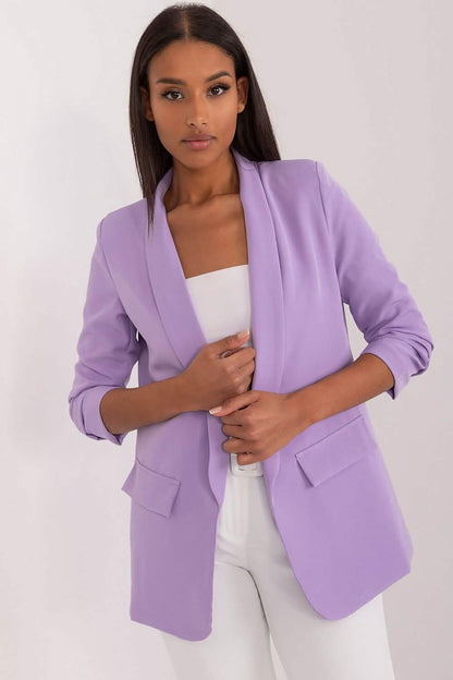 Lilac-colored blazer with ruched sleeves and lapels worn over a white top.