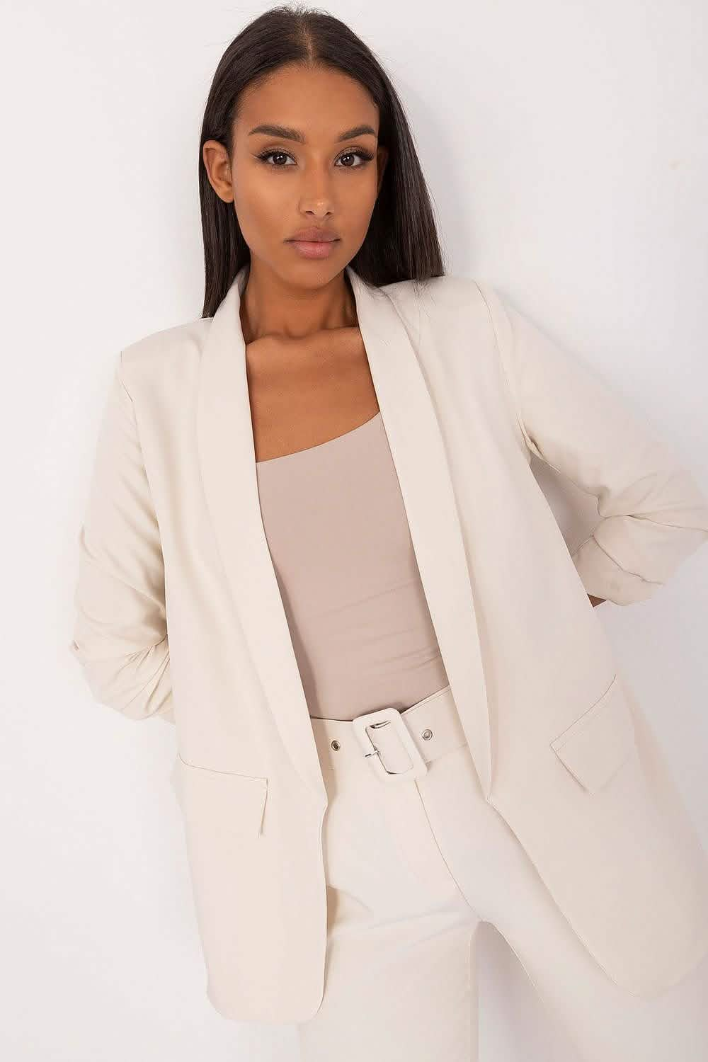 Crisp white blazer with a shawl collar worn over a beige tank top.