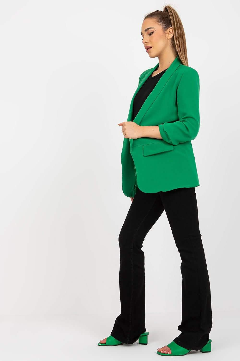 Bright green blazer worn with black pants and matching green shoes.