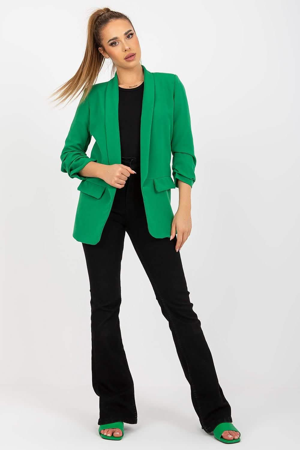 Vibrant emerald green blazer with ruched sleeves worn over a black outfit.