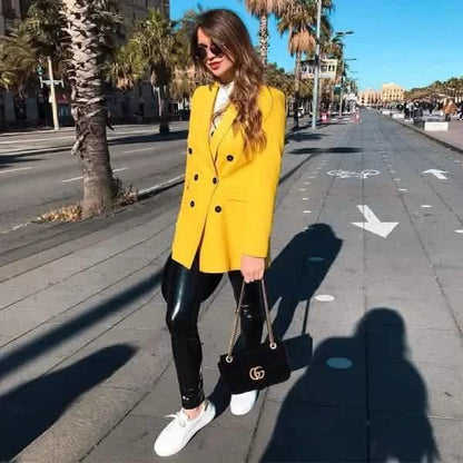 Bright yellow double-breasted blazer paired with black leather pants and white sneakers.