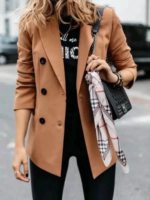 Camel-colored double-breasted blazer worn over a black top.