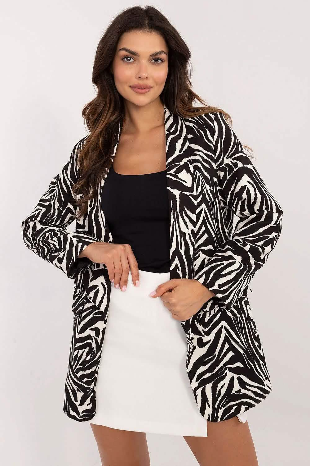 Bold black and white zebra-print blazer worn over a black top and white skirt.