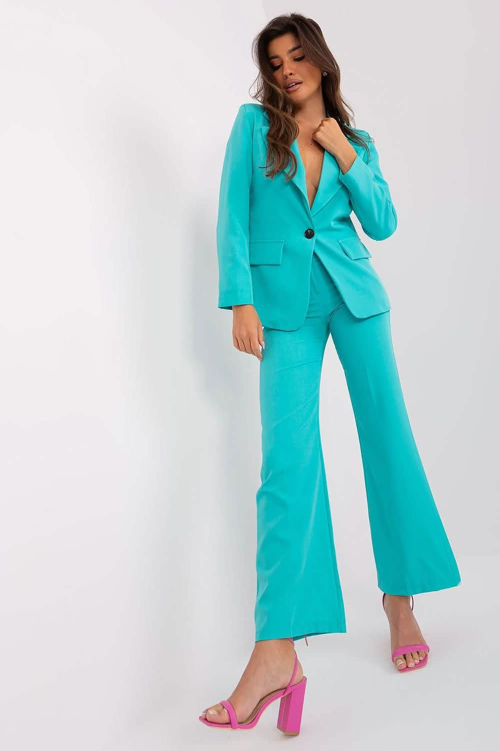 Bright turquoise pantsuit paired with pink heels.